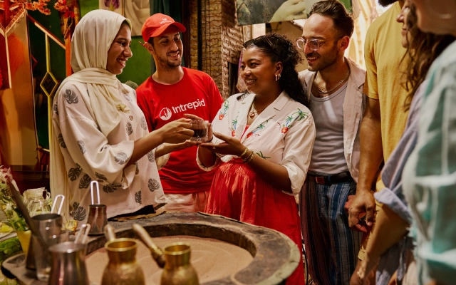People in a market sipping tea